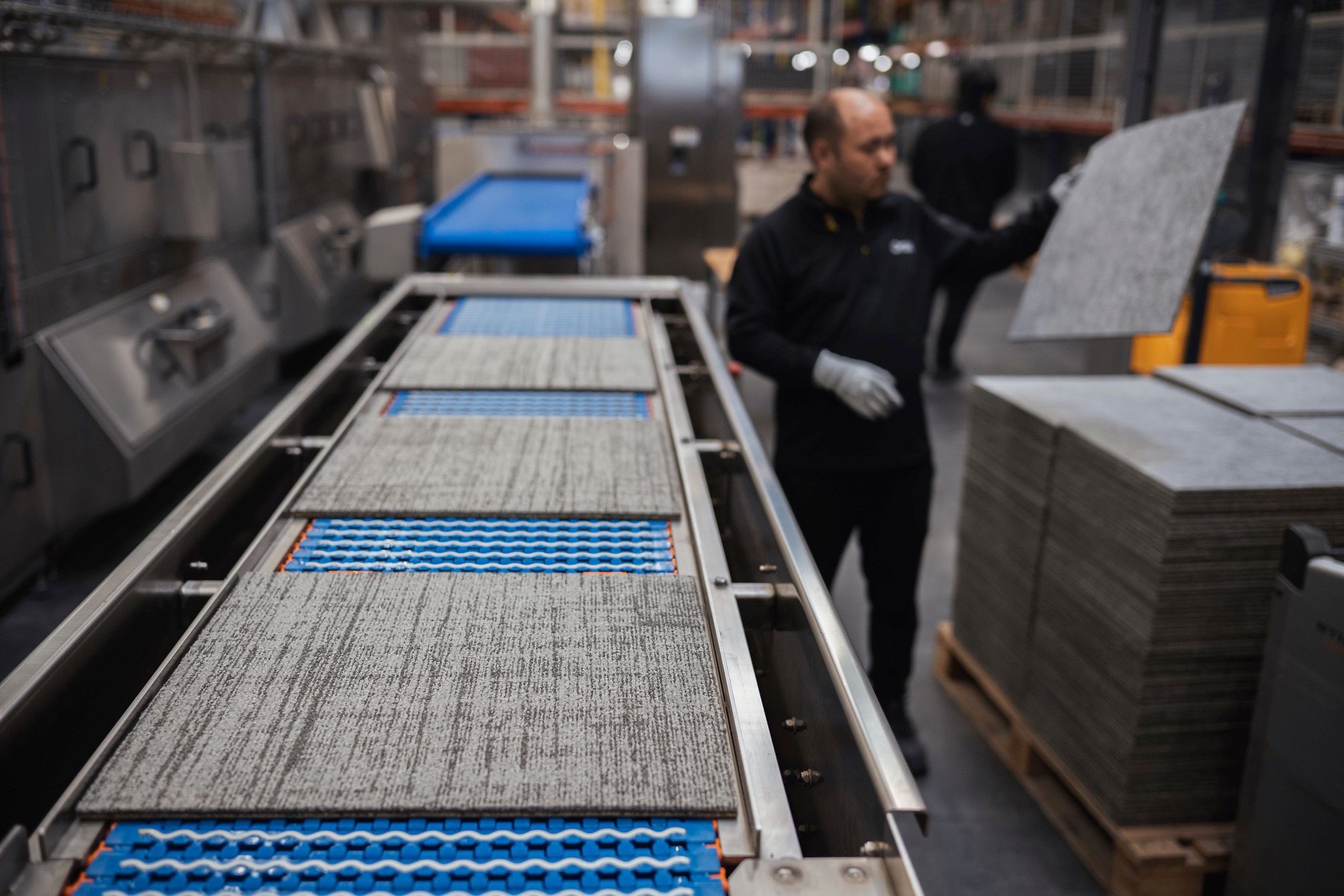 Reconditioned carpet tiles being prepared for reuse